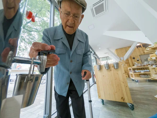 Uomo anziano alla ricerca di prodotti a zero rifiuti organici negozio locale . — Foto Stock