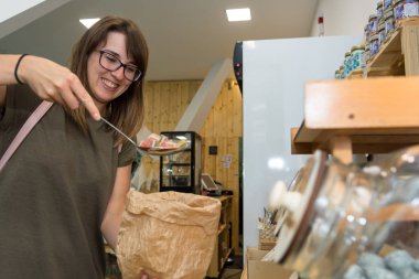 Mutlu kadın müşteri bazı lezzetli şekerler toplama.