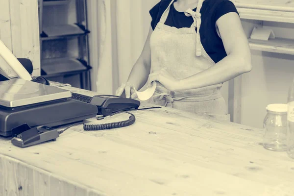 Detail of female hands printing a receipt from a POS terminal.