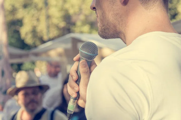 Man delivering a speach in front of live audience outdoor. — Stock Photo, Image