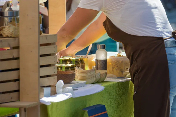 Obsluhovat zákazníky na venkovním trhu se zdravými místními produkty. — Stock fotografie