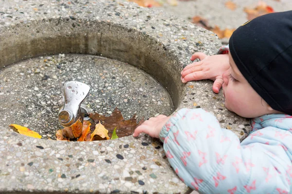 Siyah şapkalı genç bir kız, dışarıdaki içki istasyonunu keşfediyor..