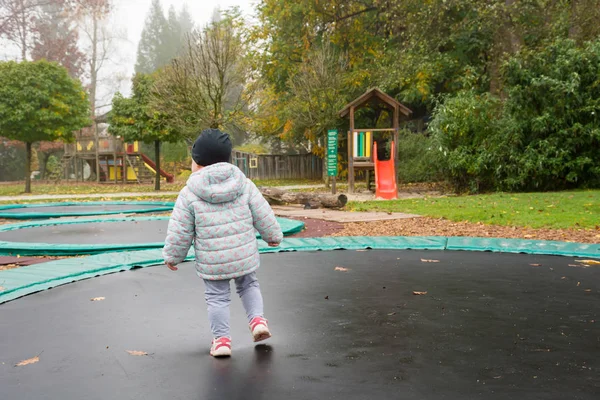 Baby dívka stojící na trampolíně venku. — Stock fotografie