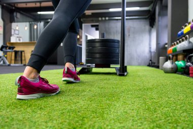 Yerel spor salonunda kızak iten kadınların düşük açılı görüntüsü.