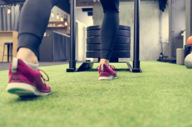 Yerel spor salonunda kızak iten kadınların düşük açılı görüntüsü.