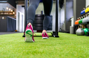 Yerel spor salonunda kızak iten kadınların düşük açılı görüntüsü.