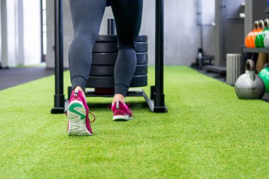 Yerel spor salonunda kızak iten kadınların düşük açılı görüntüsü.