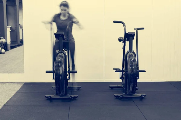 Концепция размытия движения женщины-тренера, выполняющей упражнения на велосипеде . — стоковое фото