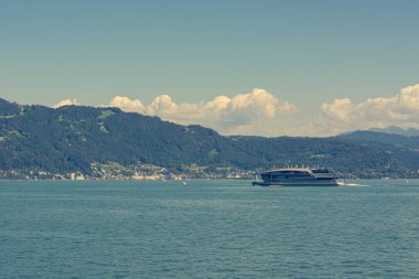 Güneşli bir günde, lüks bir tekne dağ gölünde yelken açıyor..