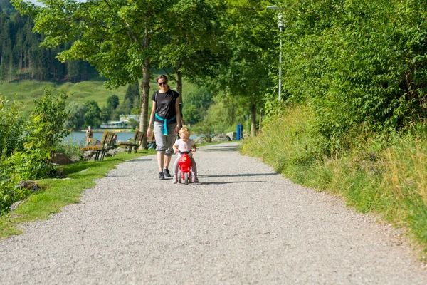 Nettes blondes Mädchen reitet rotes Motorrad im Freien. — Stockfoto