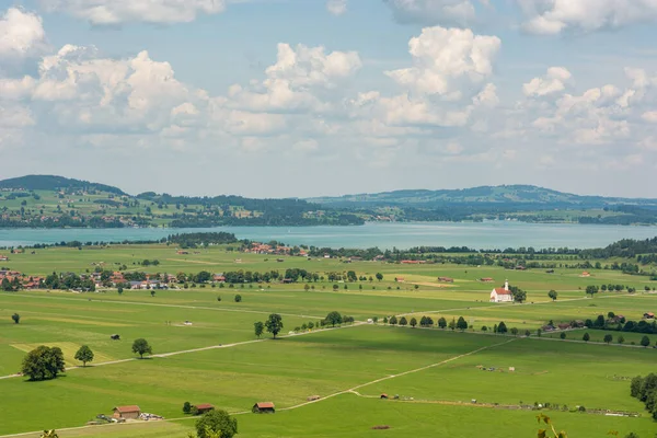 Panoramisch uitzicht op rivierland met groene weiden en velden. — Stockfoto
