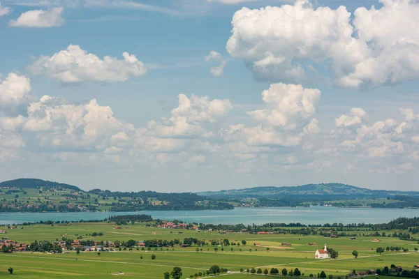 Panoramatický výhled na říční krajinu se zelenými pastvinami a poli. — Stock fotografie