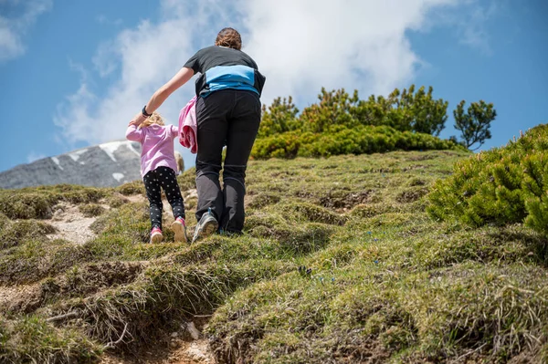 Visão traseira de mãe e filha enfrentando encosta íngreme nas montanhas. — Fotografia de Stock