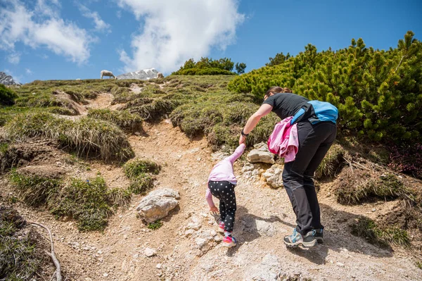 Visão traseira de mãe e filha enfrentando encosta íngreme nas montanhas. — Fotografia de Stock