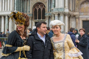 Venedik, İtalya - 30 Ocak 2016: Piazza San Marco veya Venedik 'teki St Marks Meydanı - Turistlerle poz veren güzel maskeler