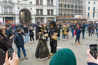 Venedik, İtalya - 30 Ocak 2016: Piazza San Marco veya Venedik 'teki St Marks Meydanı - Turistlerle poz veren güzel maskeler