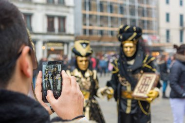 Venedik, İtalya - 30 Ocak 2016: Piazza San Marco veya Venedik 'teki St Marks Meydanı - Ünlü Venedik maskelerinin fotoğraflarını çeken turist