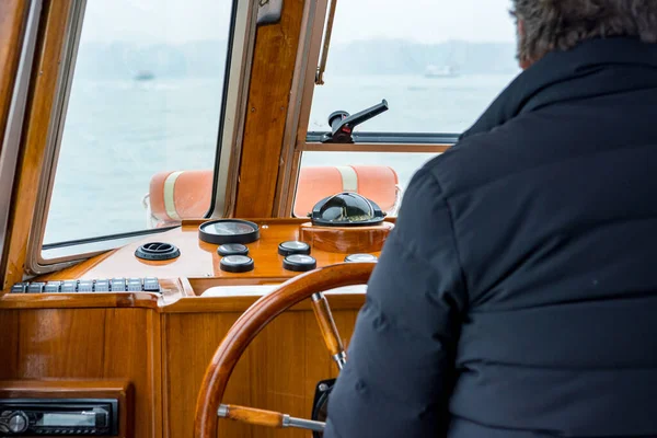 Capitão dirigindo um velho barco de madeira - visão traseira . — Fotografia de Stock