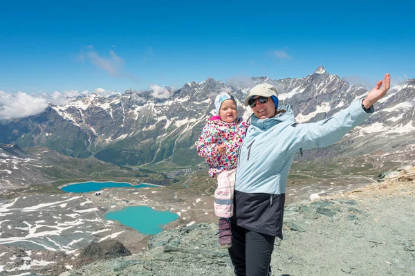 Mãe feliz segurando sua filha cercada com paisagem pitoresca montanha. — Fotografia de Stock