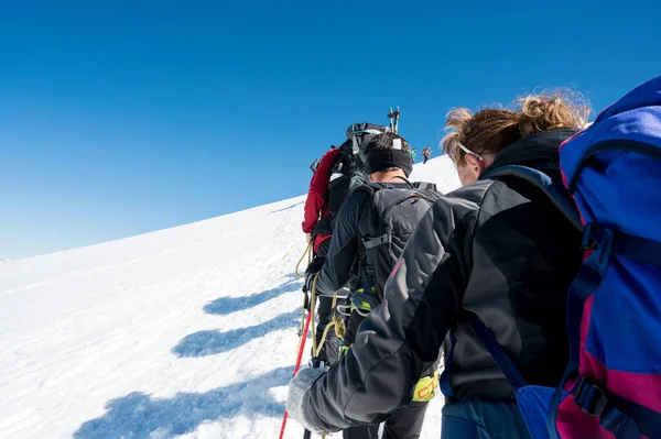 Punto de vista de los miembros del equipo de cuerda con montañeros caminando sobre nieve y hielo en tiempo soleado. — Foto de Stock
