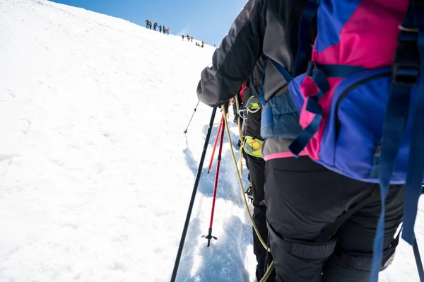 Point de vue des membres de l'équipe de corde avec des alpinistes marchant sur la neige et la glace par temps ensoleillé. — Photo