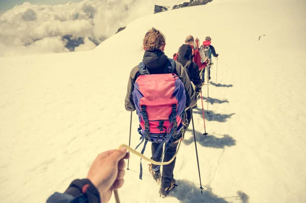 雪上を歩く登山家や晴天時の氷とロープチームメンバーの視点. — ストック写真