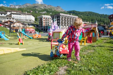 Açık alanda plastik tren taşıyan sevimli sarışın kız..