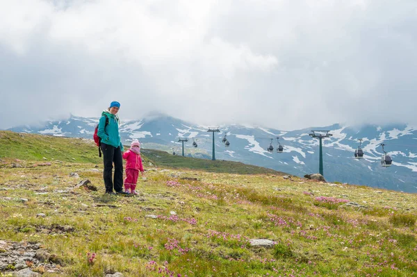 Anne ve kızı yeşil alp çayırlarında yürüyüş yapıyor.. — Stok fotoğraf