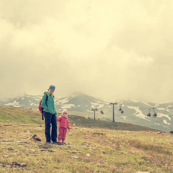 Mor och dotter vandrar gröna alpängar. — Stockfoto