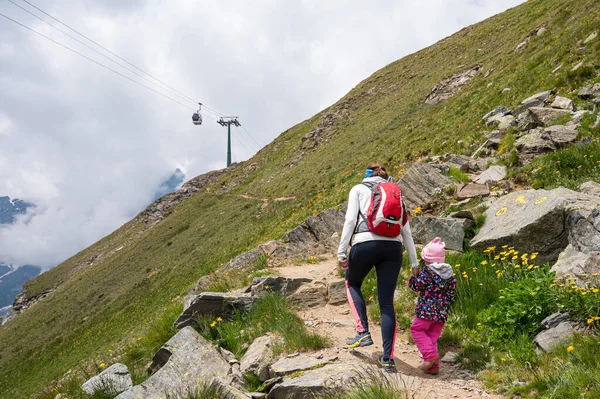 Мать и дочь путешествуют рука об руку по горным пастбищам. — стоковое фото