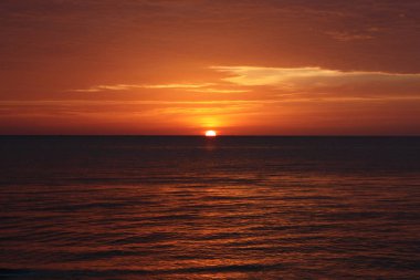Okyanusun üzerinde kırmızı gün batımı