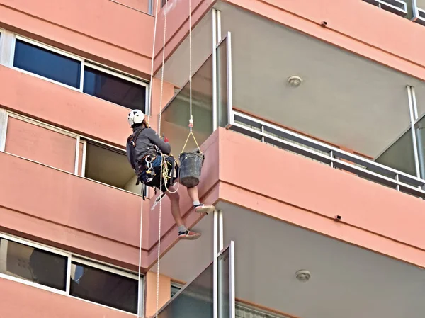 Roped artisan on the exterior of a skyscraper