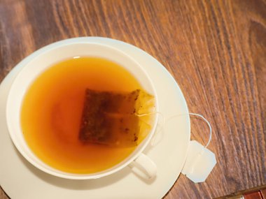 Taze demlenmiş siyah çay ile beyaz hassas çay fincanı.       