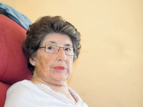 Retrato lateral muy bonito de una mujer mayor a la edad de 83 años con pelos grises y lápiz labial rojo . — Foto de Stock