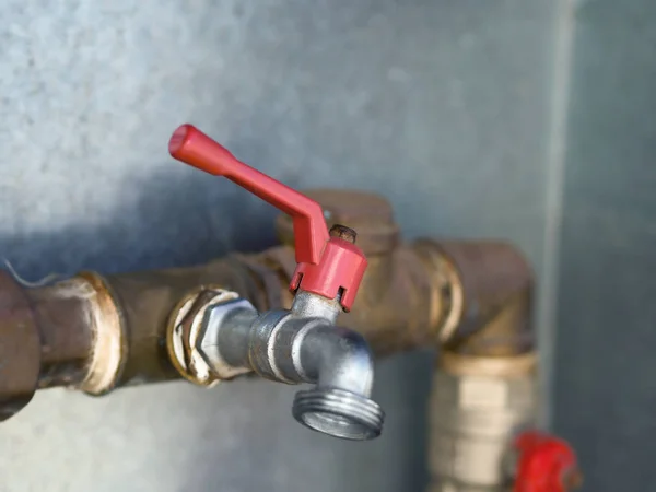 Red inlet regulator at a water pipe — Stock Photo, Image