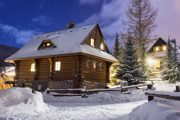 Casa de madera iluminada por la noche Imagen de stock