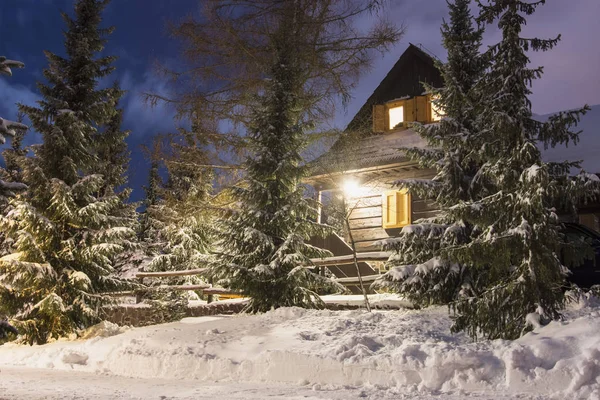 Casa de madera iluminada por la noche Imágenes de stock libres de derechos