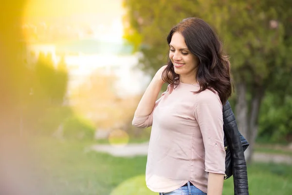 Powerful middle-age woman smiling, holds her jacket over the shoulder