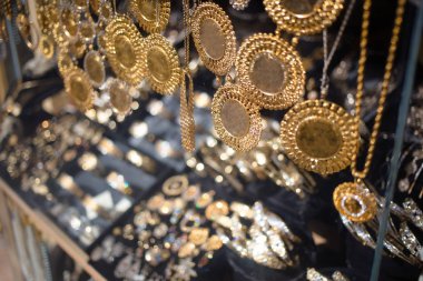 Kuyumcu vitrininde altın kolyeler, altın sikkeler.