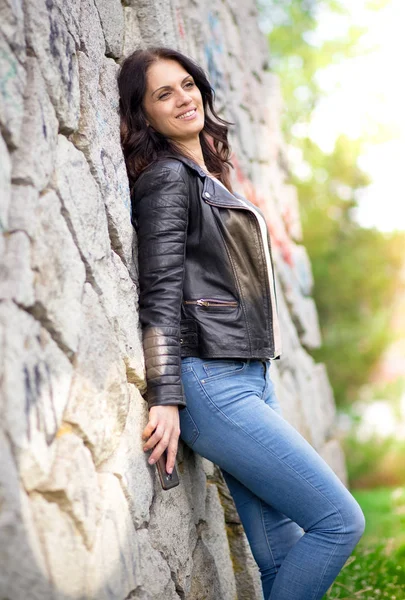 Beautiful middle-age woman in black leather jacket smiling broadly — Stockfoto