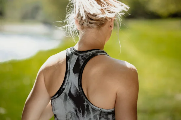 Крупный план спины спортивной блондинки в спортивной футболке . — стоковое фото