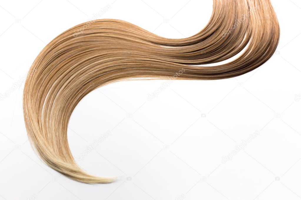 Piece of blonde hair on white isolated background. Hair care, healthy hair