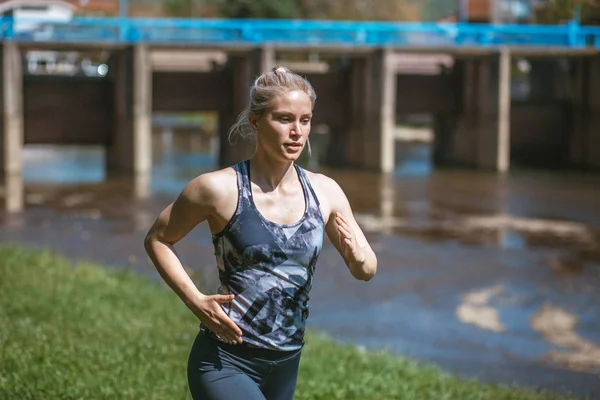 Photo of young blonde girl wearing sportswear running in the nature — Stock Photo, Image
