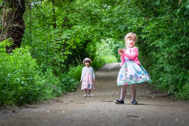 Renkli elbiseler içinde iki küçük kız, yürüyüş. Doğa, açık havada.