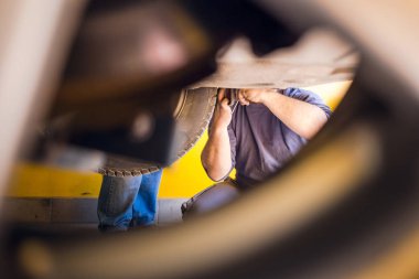 Arabayı tamir eden araba tamircilerinin fotoğrafı. Araba dükkanının içinde