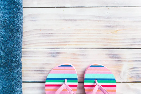 Pink flip-flops on white wooden background with blue towel on the side — Stock Photo, Image