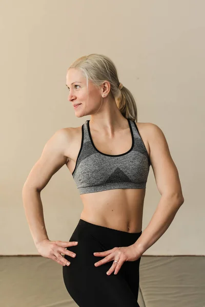 Vacker blond kvinnlig tränare visar hennes muskler. Hälsosam, aktiv livsstil — Stockfoto