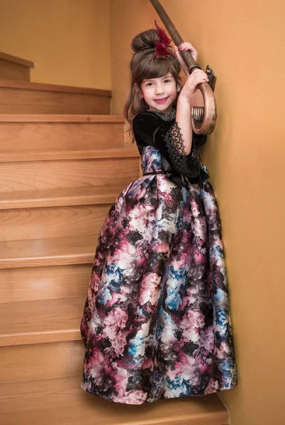 Маленька принцеса в довгій барвистій сукні, що стоїть на сходах її будинку . — стокове фото