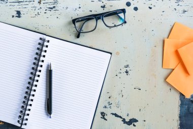 Turuncu blok kağıtları, Notebook, kalem, gözlük ile Vintage ofis masası düz Lay görünümü.