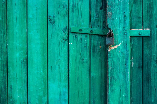 Green wooden background texture with a padlock. Vertical planks, bars